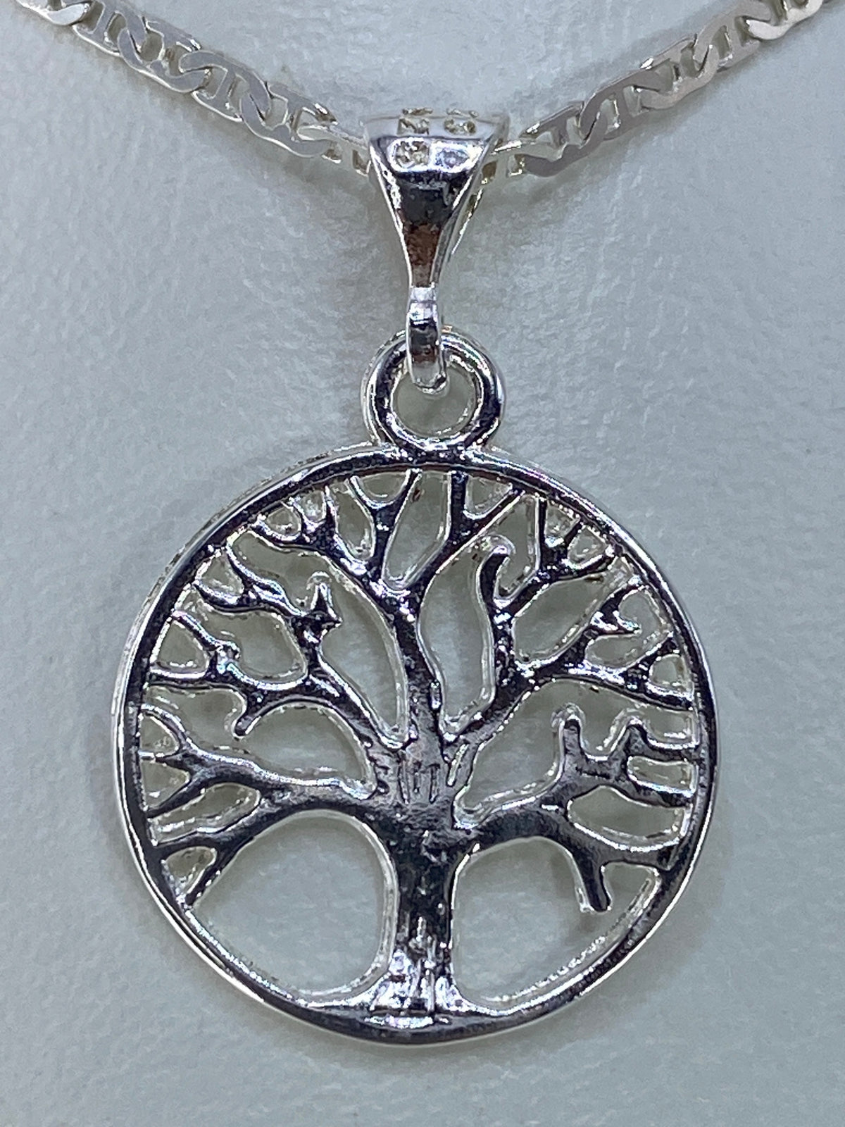 Vista frontal del dije Árbol de la Vida mostrando el detalle del repujado