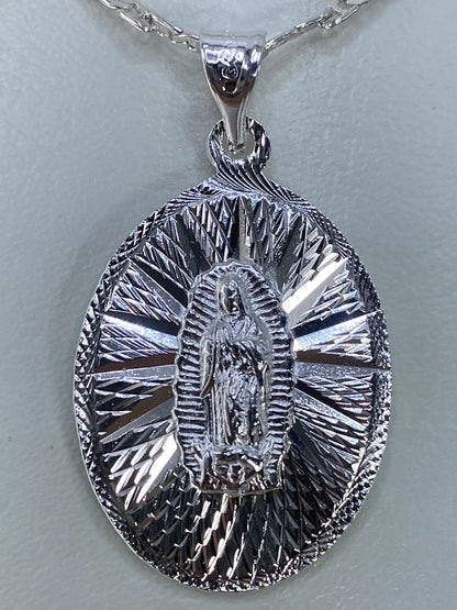 Dije Guadalupano de plata repujada en tamaño natural mostrando el halo radiante