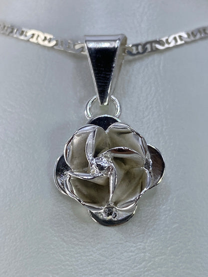 Detalle del repujado: pétalos volumétricos y textura delicada de la flor de plata