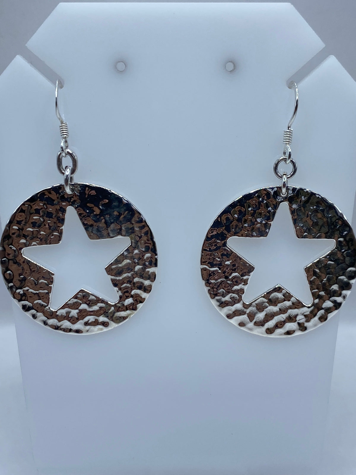 Par de aretes de plata repujados con diseño de estrella abierta y textura granulada