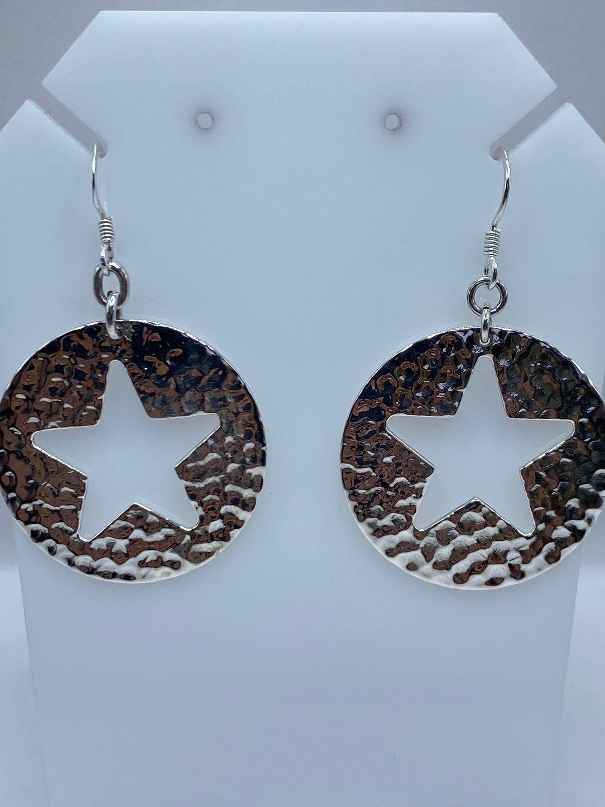 Aretes de estrella abierta en técnica de repujado, vista frontal mostrando la textura