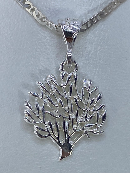 Dije de plata 925 con diseño floral calado, colgando de una cadena plateada