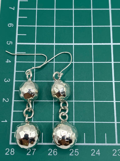 Aretes sobre regla de medición mostrando el largo de 5.1 cm del par
