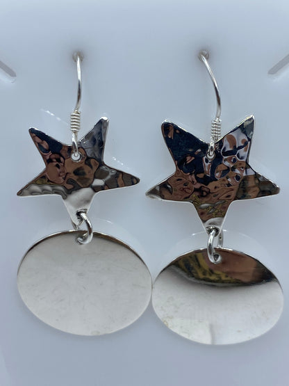 Par de aretes de plata 925 con estrella martillada superior y disco espejo pulido inferior, colgando del gancho