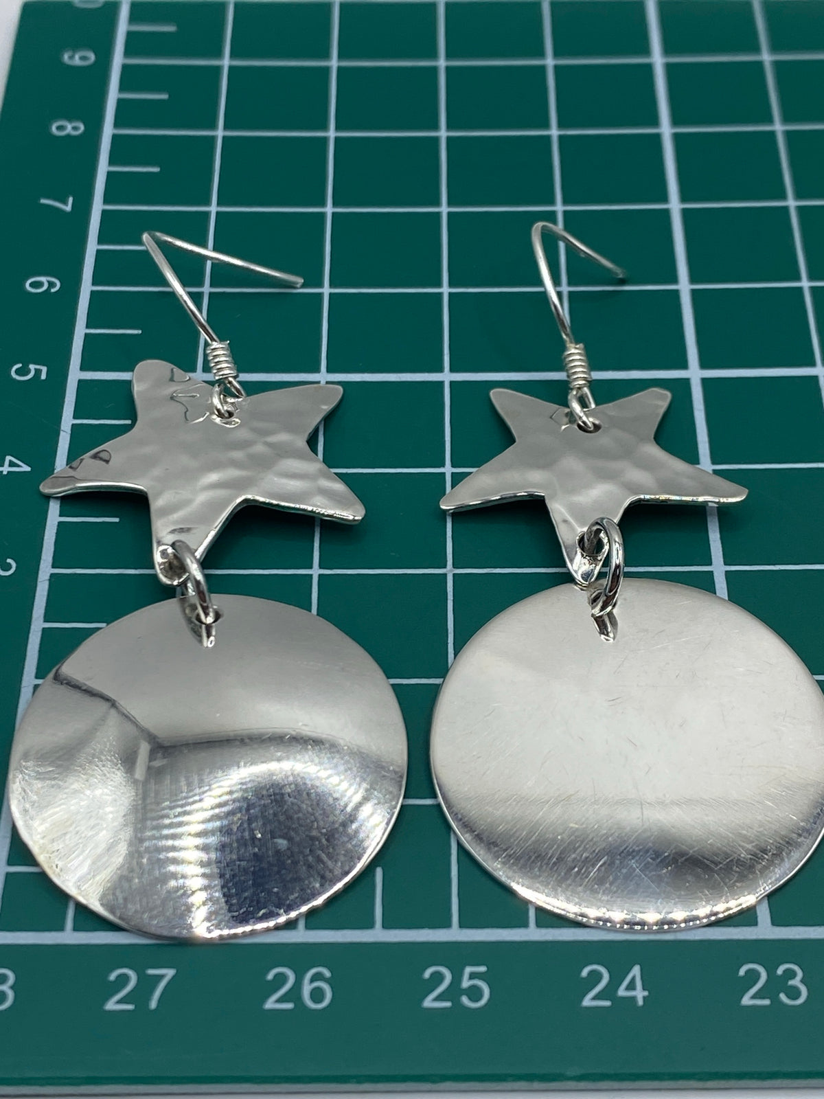 Aretes colocados sobre escala de centímetros indicando largo de 6.3 cm