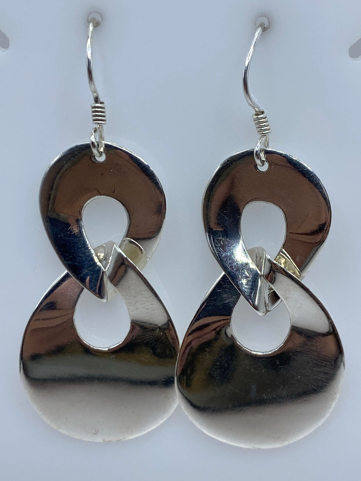 Aretes de plata calado con diseño geométrico hueco, 5.4 cm de largo, sobre superficie blanca