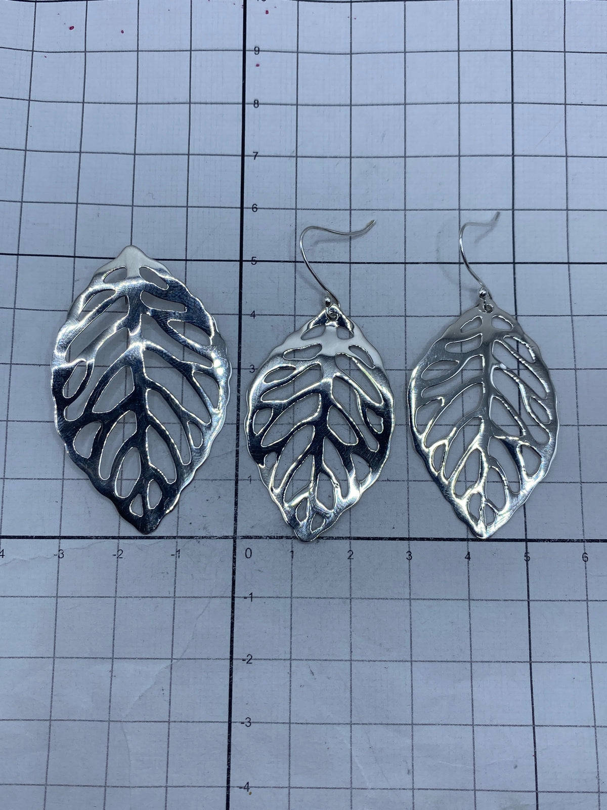 Aretes de plata calada vistos desde el frente, con el sello de autenticidad 925 visible