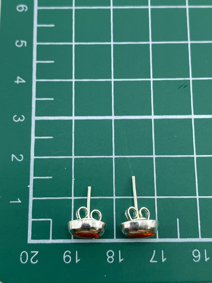 Comparación de tamaño: aretes junto a moneda para escala