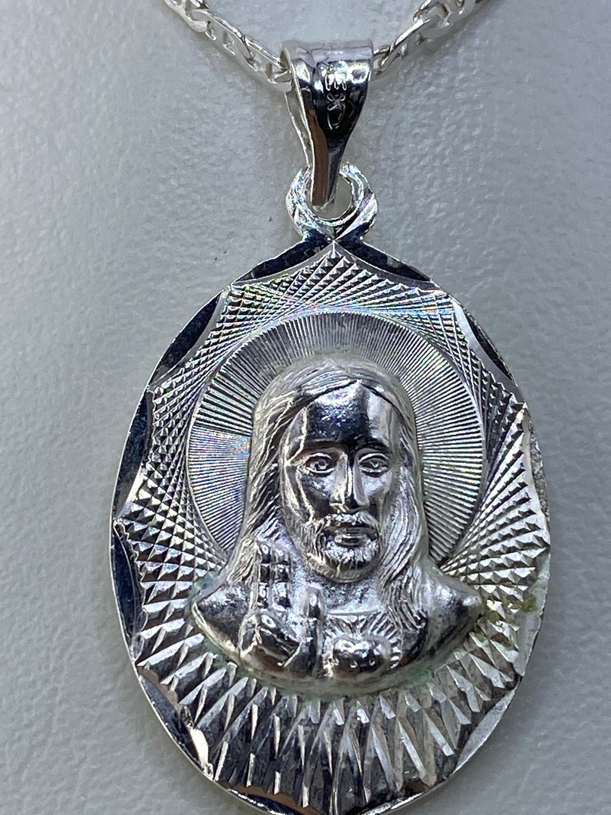 Dije de plata sobre regla de medidas, mostrando 3.5 cm de largo