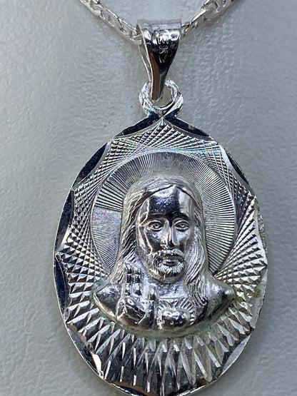 Dije de plata sobre regla de medidas, mostrando 3.5 cm de largo