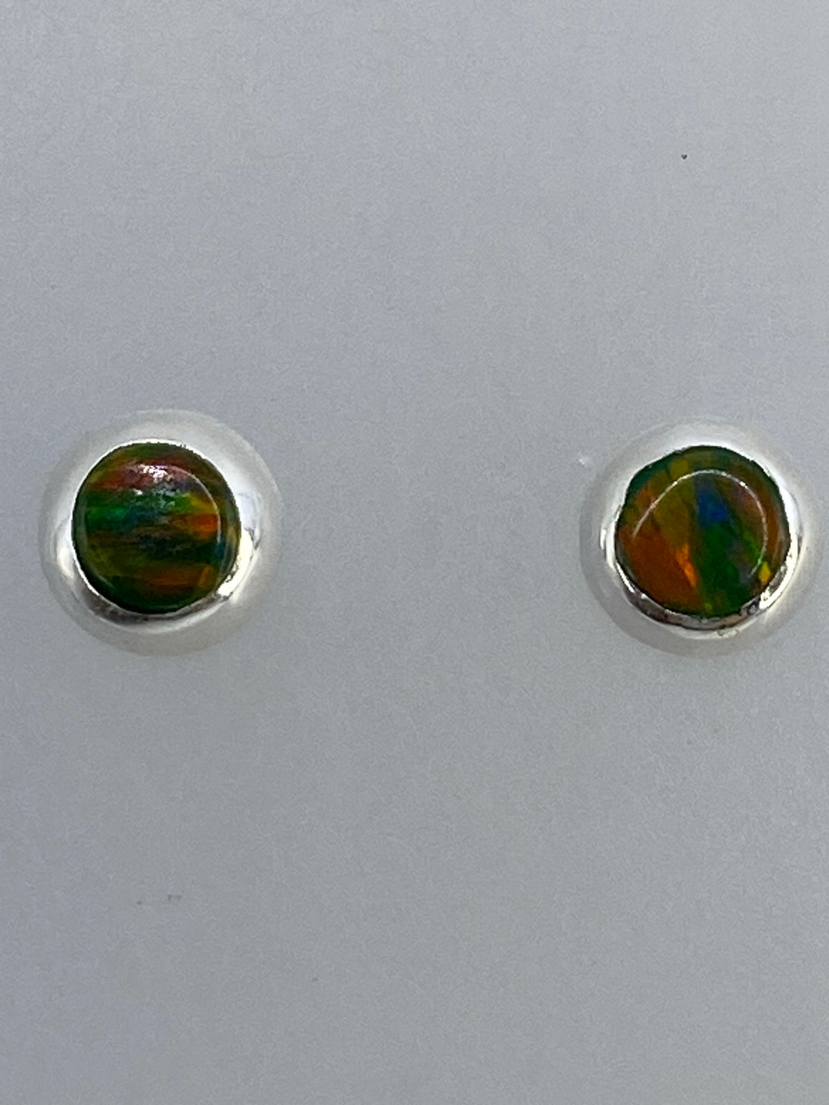 Par de aretes de plata 925 con ópalo de fuego multicolor, mostrando destellos verdes, naranjas y azules