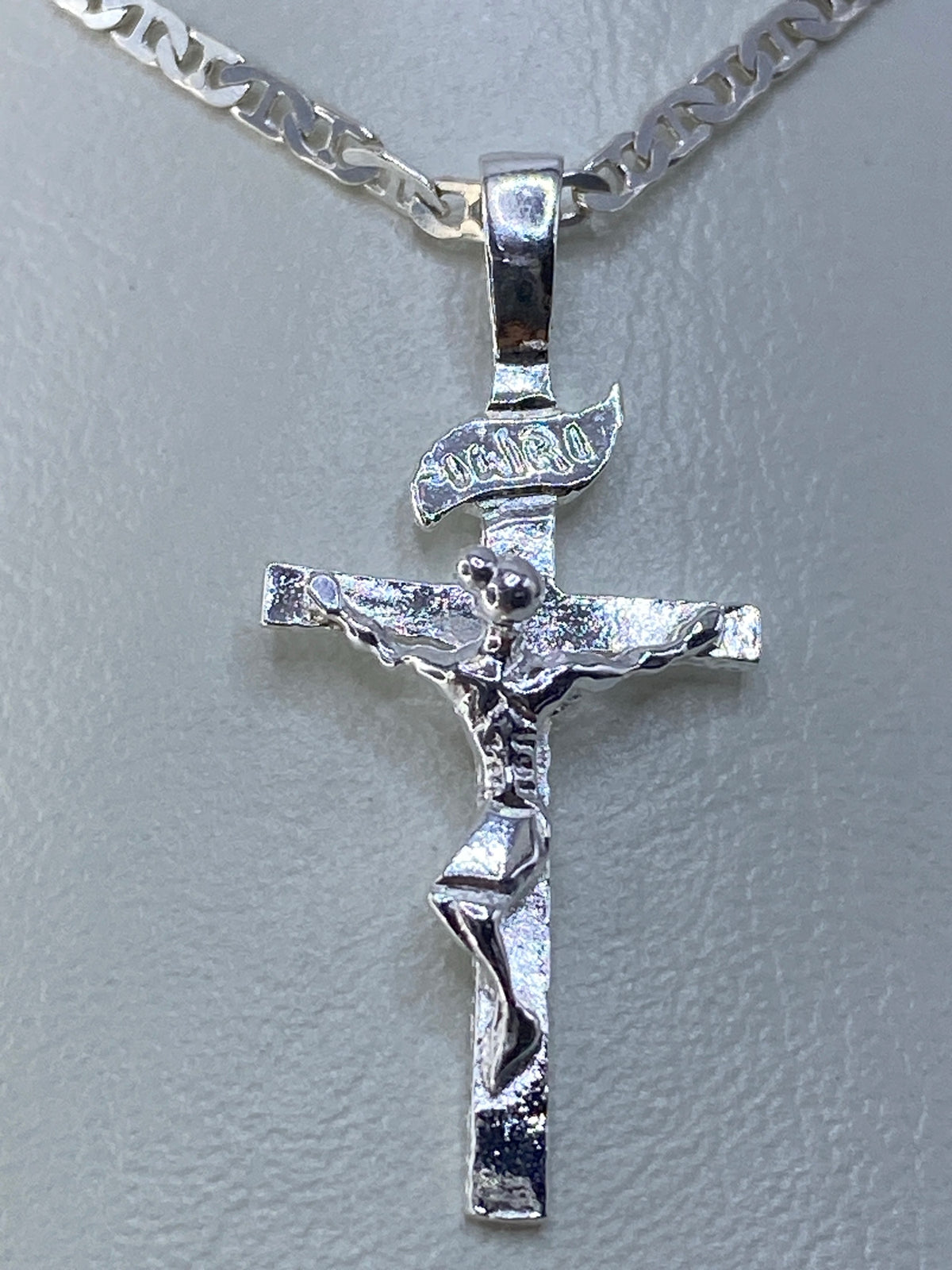 Vista frontal del crucifijo de plata con figura tallada en relieve
