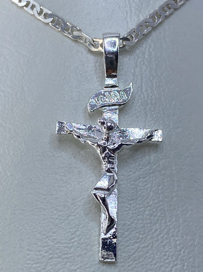 Vista frontal del crucifijo de plata con figura tallada en relieve