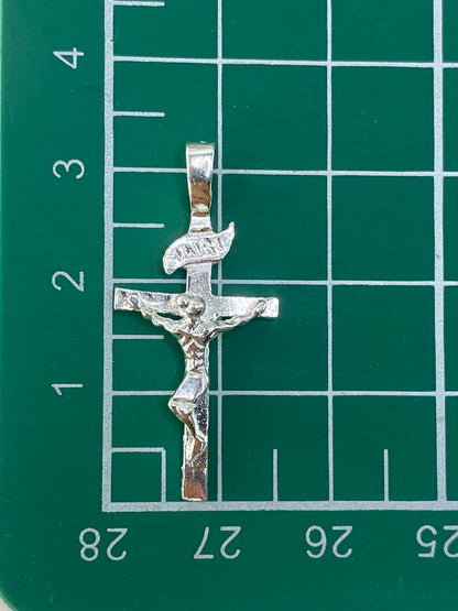 Crucifijo de plata sobre fondo blanco mostrando la marca del Quinto 925
