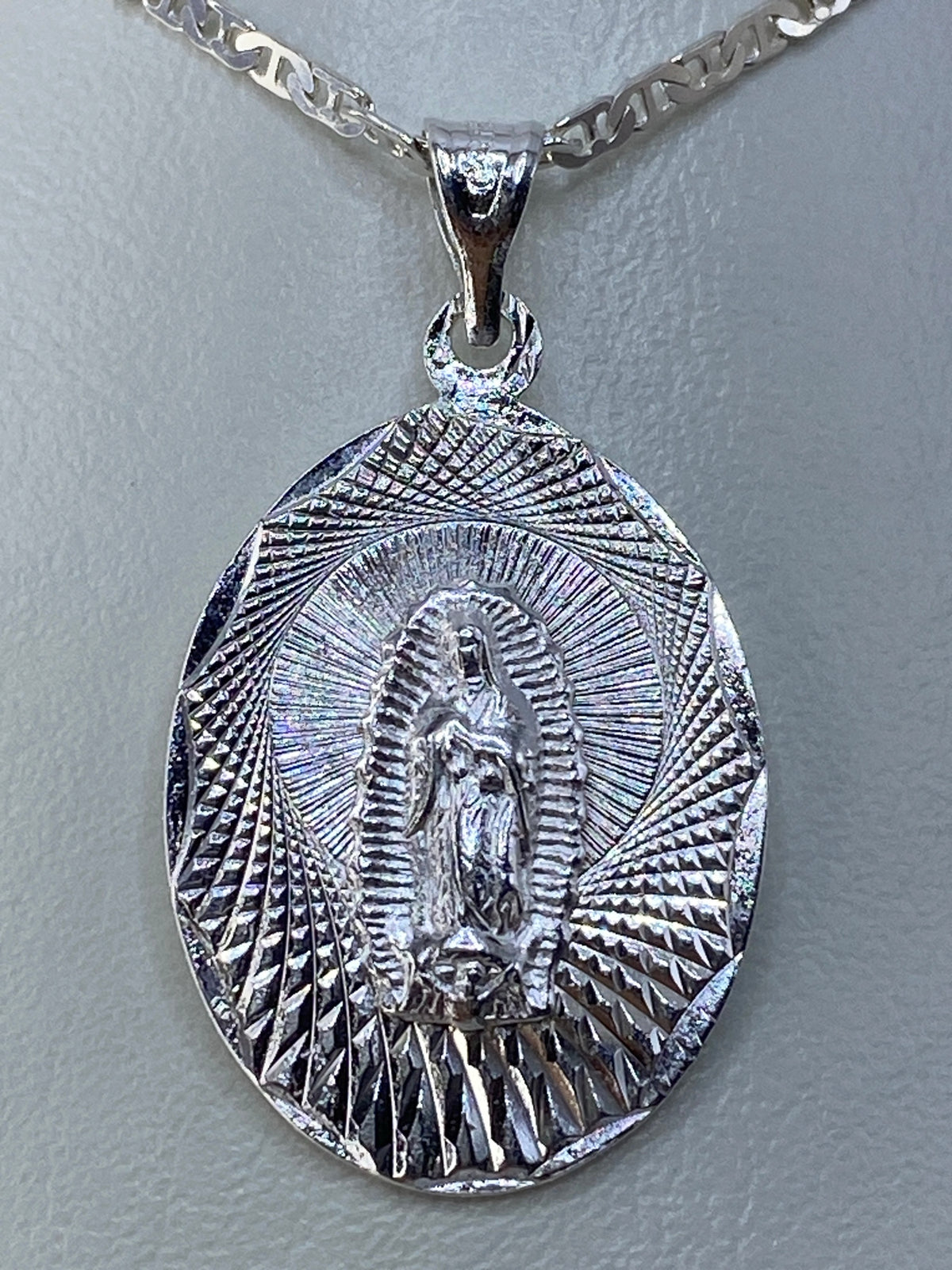 Dije Guadalupana de plata 925 repujado a mano, vista frontal con halo de rayos