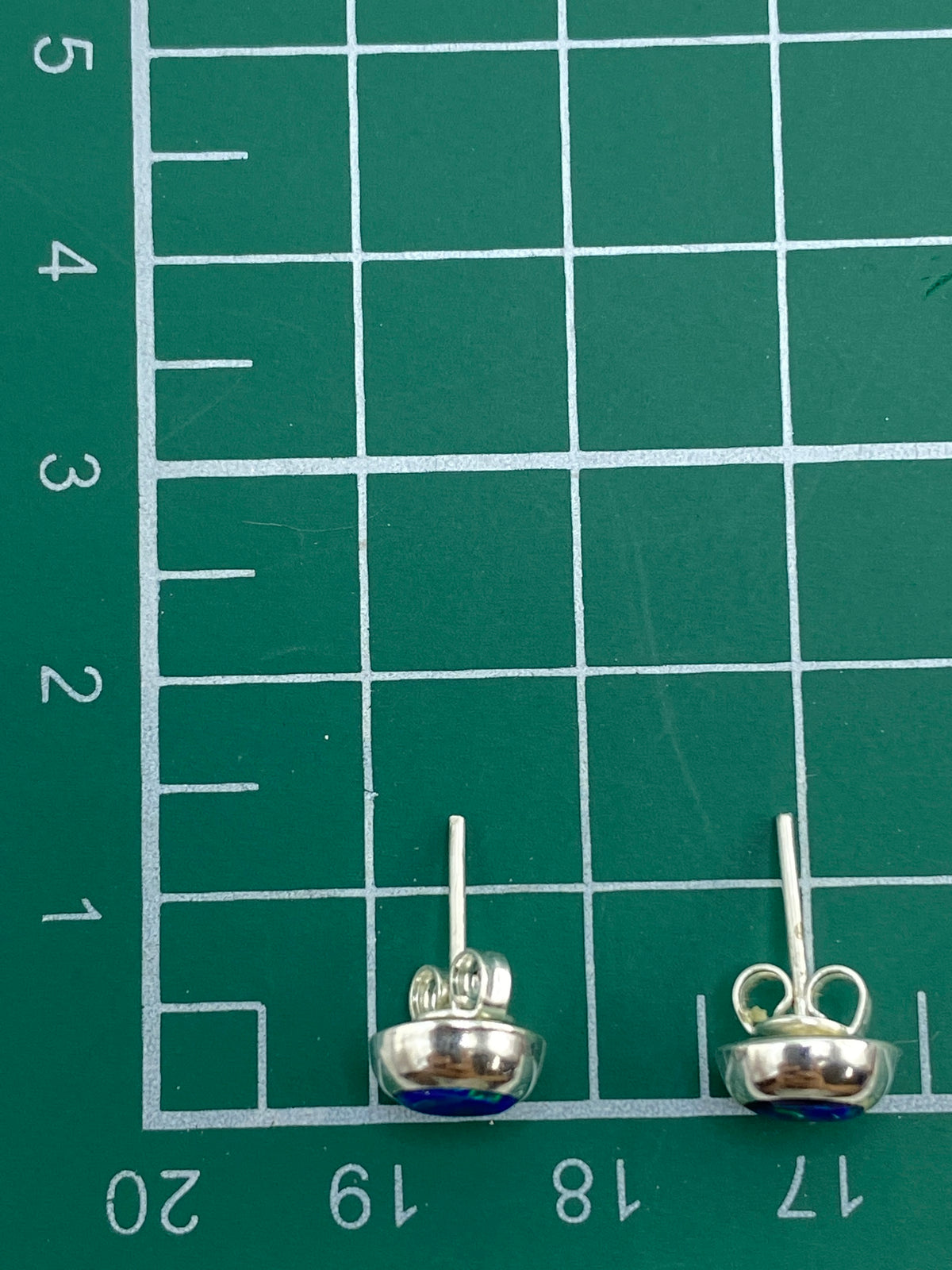 Aretes con luz natural mostrando los reflejos verdosos del ópalo de fuego