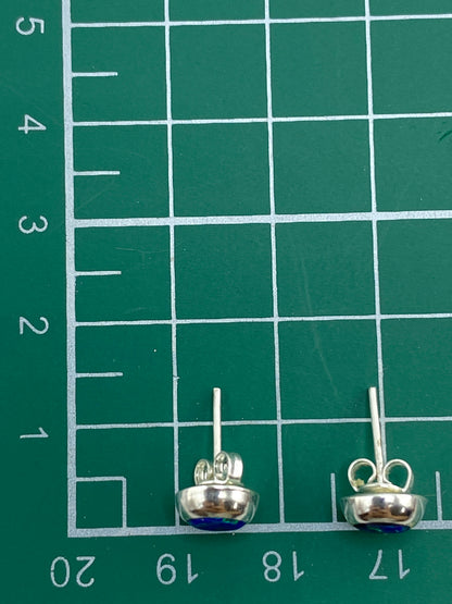 Aretes con luz natural mostrando los reflejos verdosos del ópalo de fuego