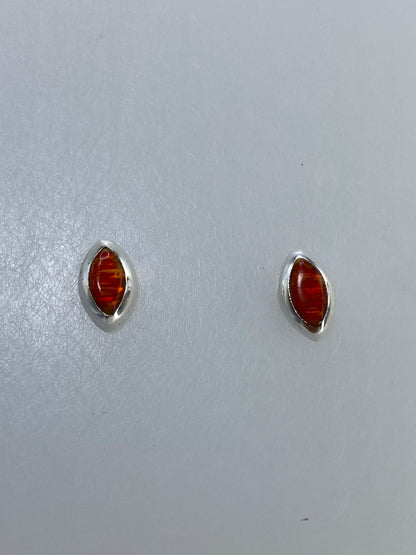 Detalle de aretes de ópalo de fuego mostrando el color naranja intenso y los destellos naturales