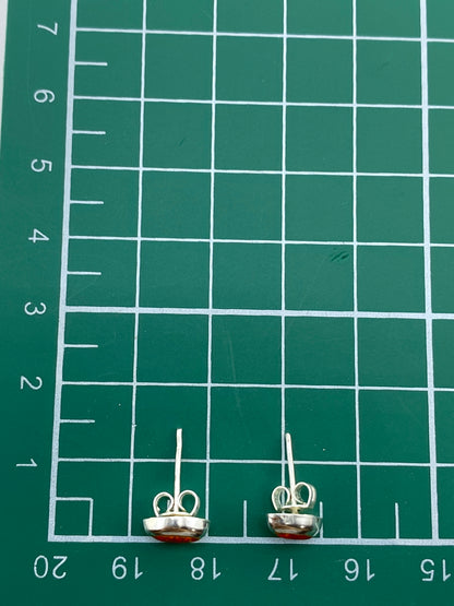Aretes de ópalo naranja sobre fondo blanco, vista de frente mostrando el Quinto 925