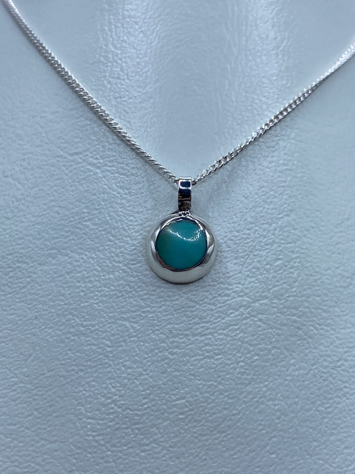 Detalle del dije de turquesa azul en plata pulida, vista frontal
