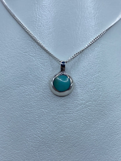 Detalle del dije de turquesa azul en plata pulida, vista frontal