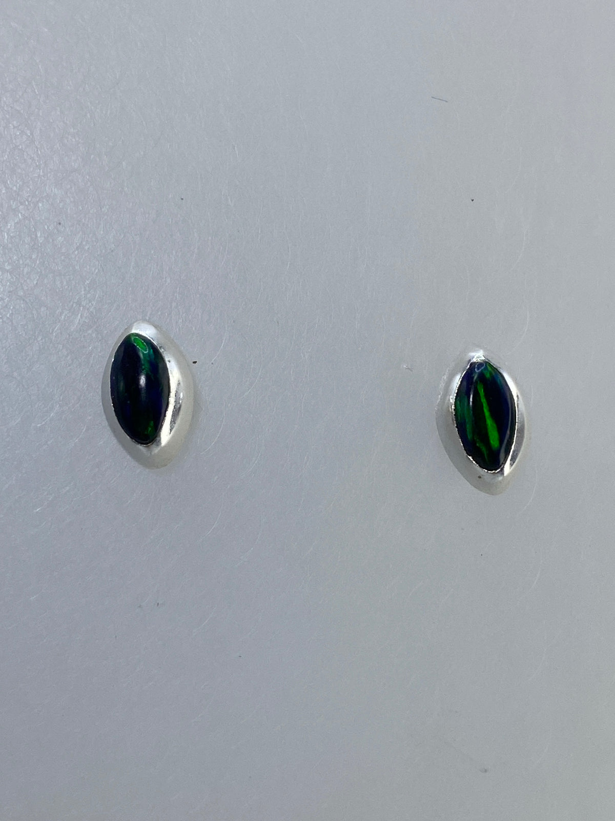 Aretes de plata con ópalo de fuego multicolor, par completo mostrando destellos naranjas, verdes y azules