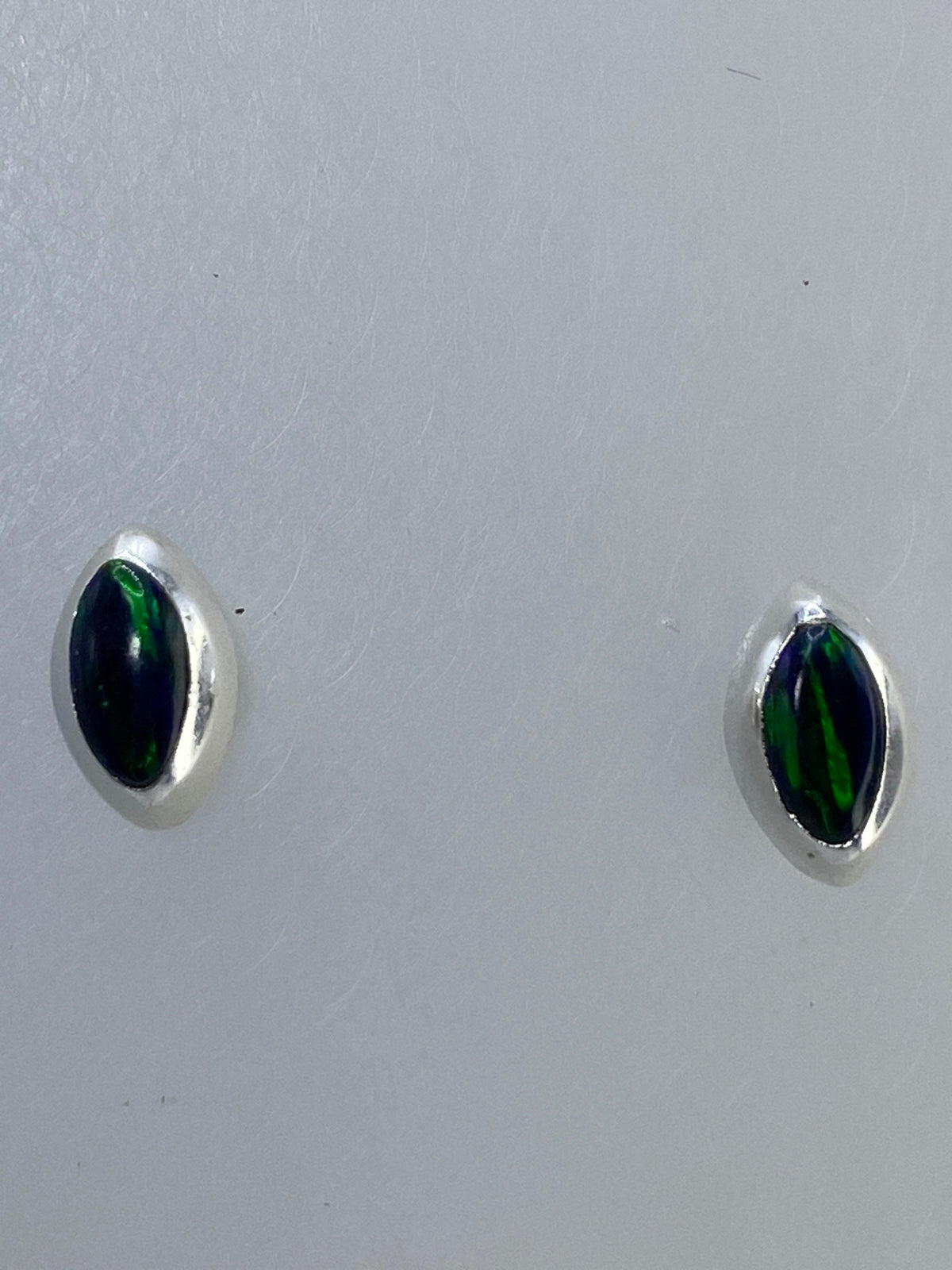 Aretes de frente mostrando la profundidad multicolor del ópalo