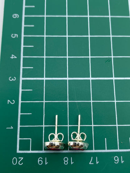 Aretes de plata con ópalo de fuego mostrando el Quinto 925 en el reverso