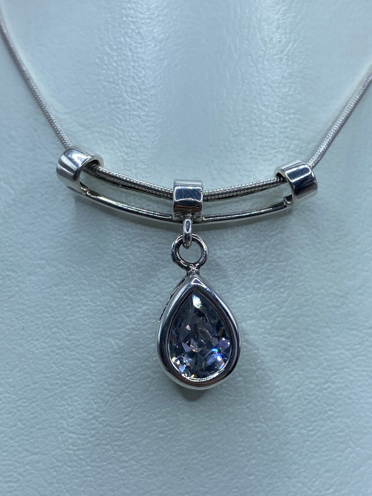 Dije de plata 925 con circonia blanca facetada en forma de gota, colgando de cadena metálica