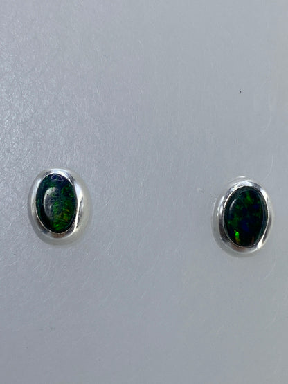 Par de aretes de plata 925 con ópalo de fuego verde engastado a mano, visto sobre fondo blanco