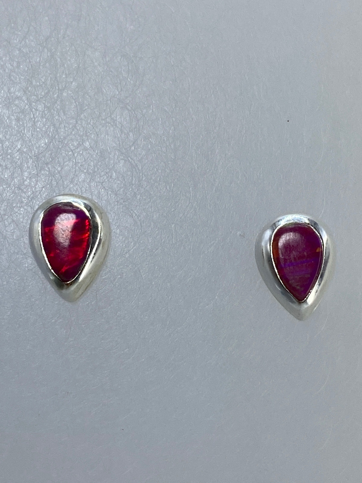 Par de aretes de plata con ópalo de fuego naranja engastado, vista frontal