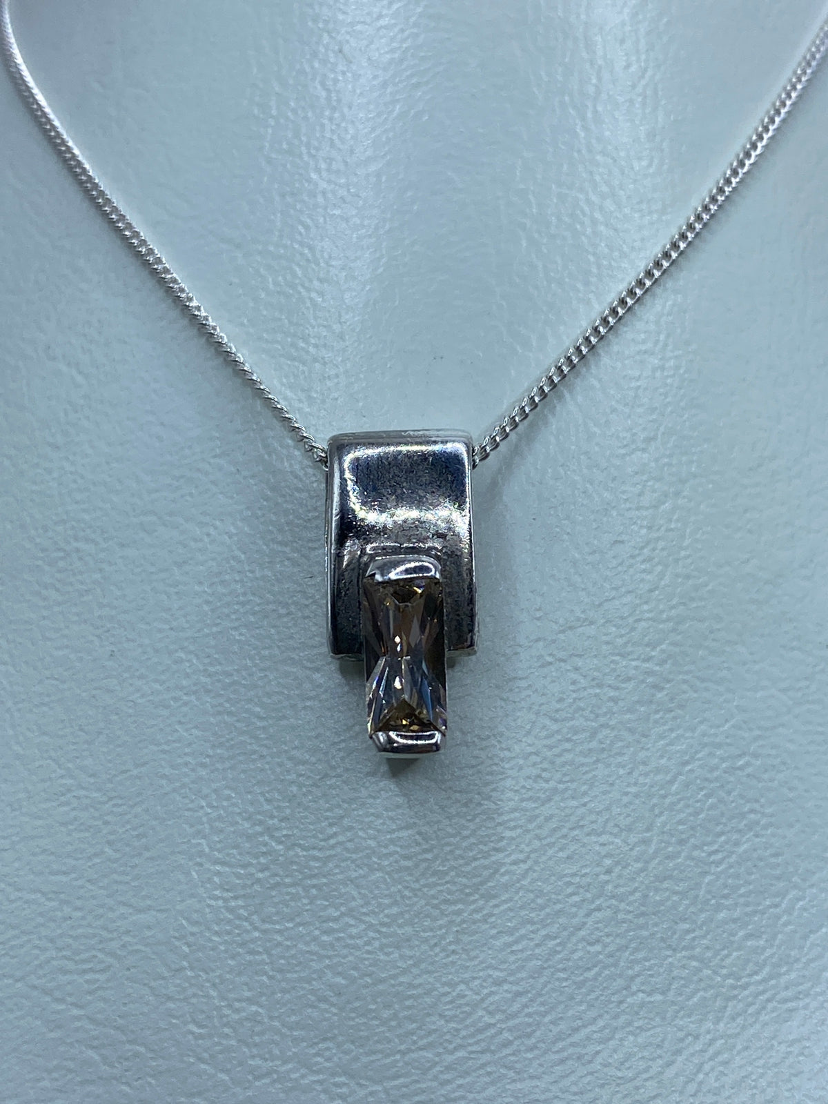 Dije de plata 925 con circonia blanca engastada, colgando de una cadena plateada