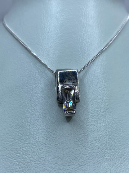 Detalle frontal del dije de plata compacto con circonia blanca brillante