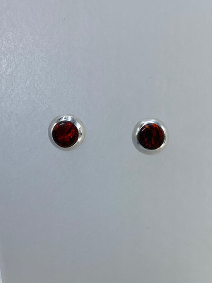 Detalle frontal de los aretes mostrando el brillo cafe del opalo de fuego