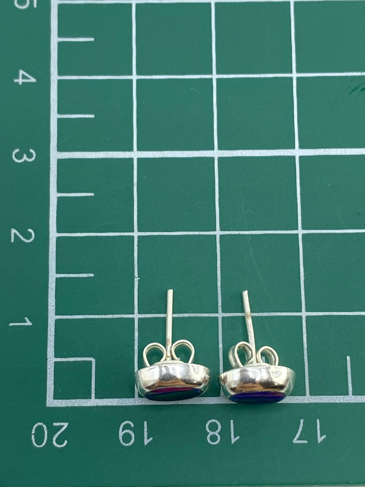 Aretes sobre escala mostrando su peso ligero de 0.87 gramos el par