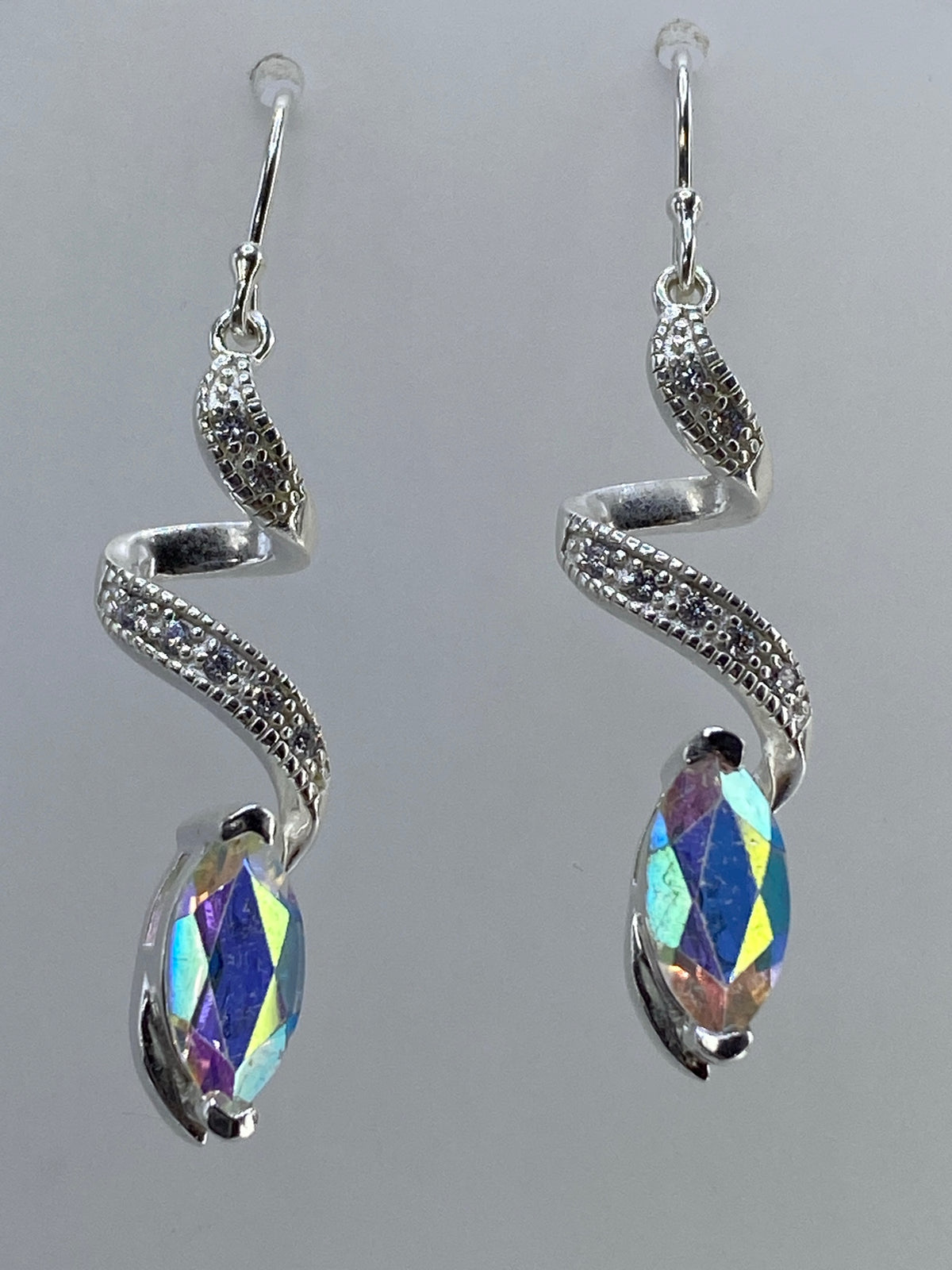 Aretes de plata serpentín con circonia multicolor azul y amarillo, sobre fondo gris