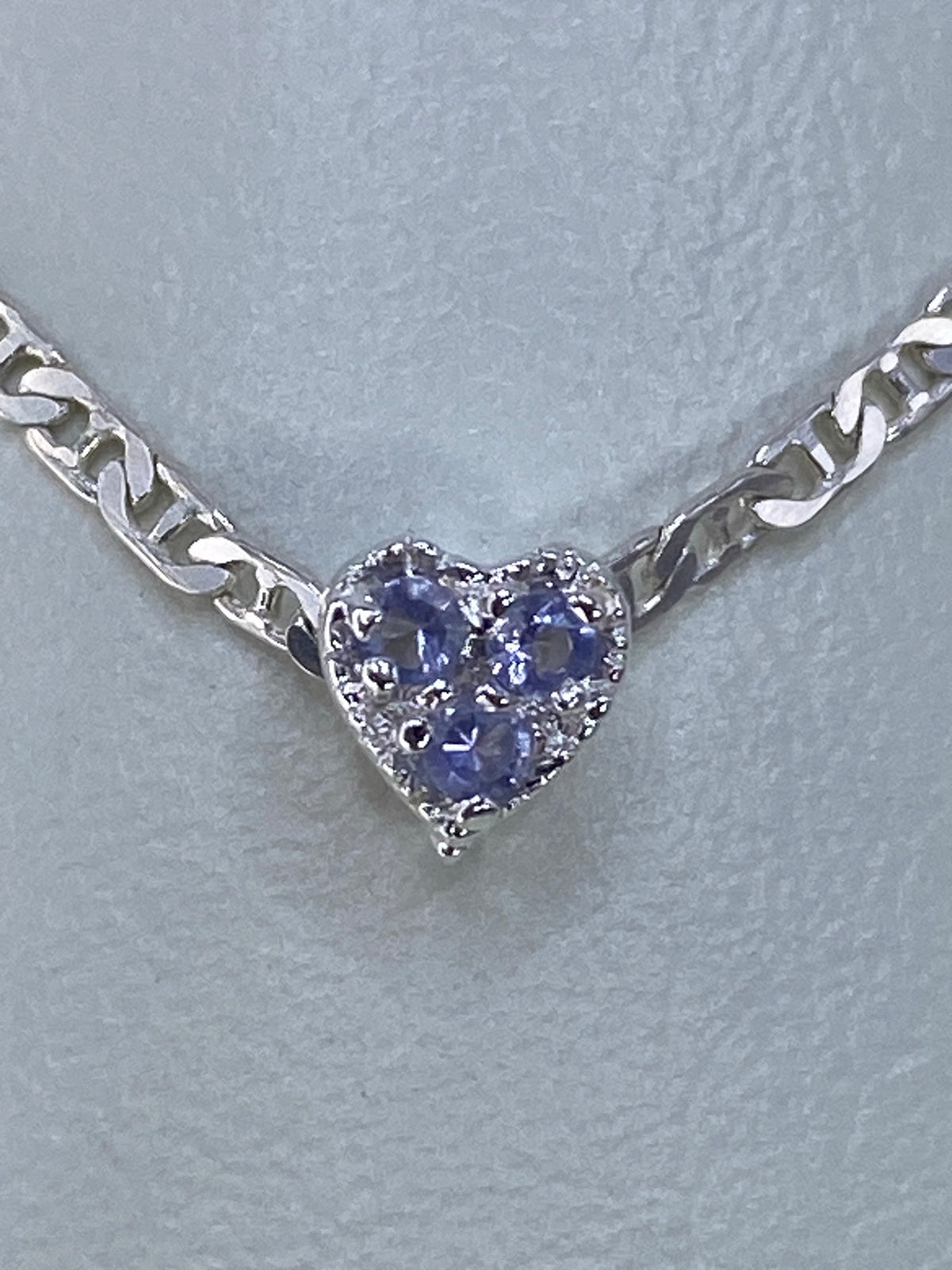 Dije corazón de plata 925 con circonia morada engastada, pende de cadena eslabonada