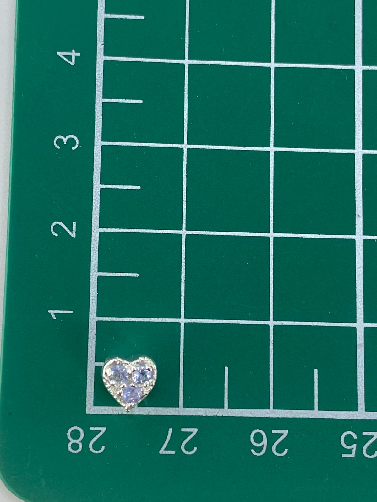 Reverso del dije corazón de plata, mostrando el trabajo de engaste a mano