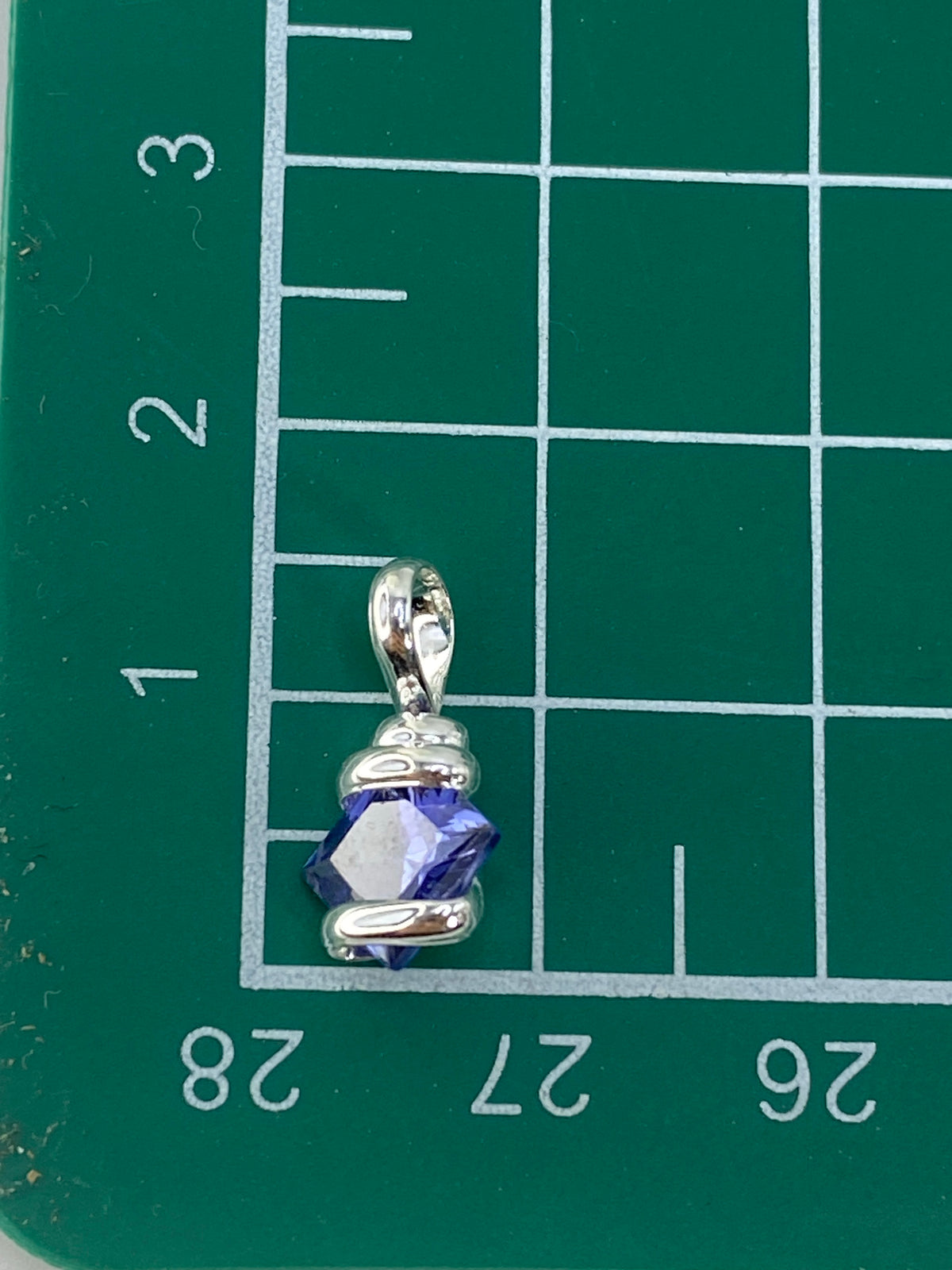 Dije de circonia junto a escala de referencia mostrando su tamaño compacto