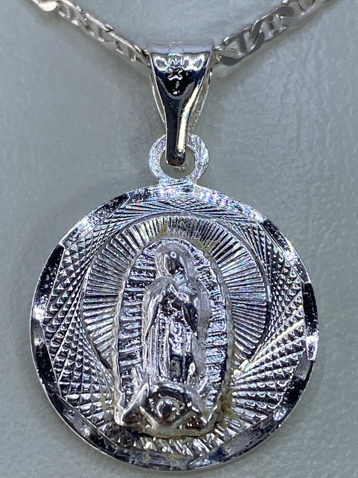 Detalle de las líneas del repujado en el dije de la Virgen de Guadalupe