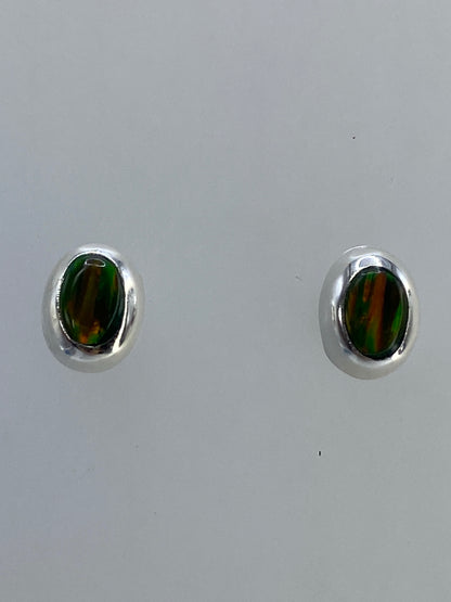 Aretes en la mano mostrando el tamaño real y el brillo del ópalo