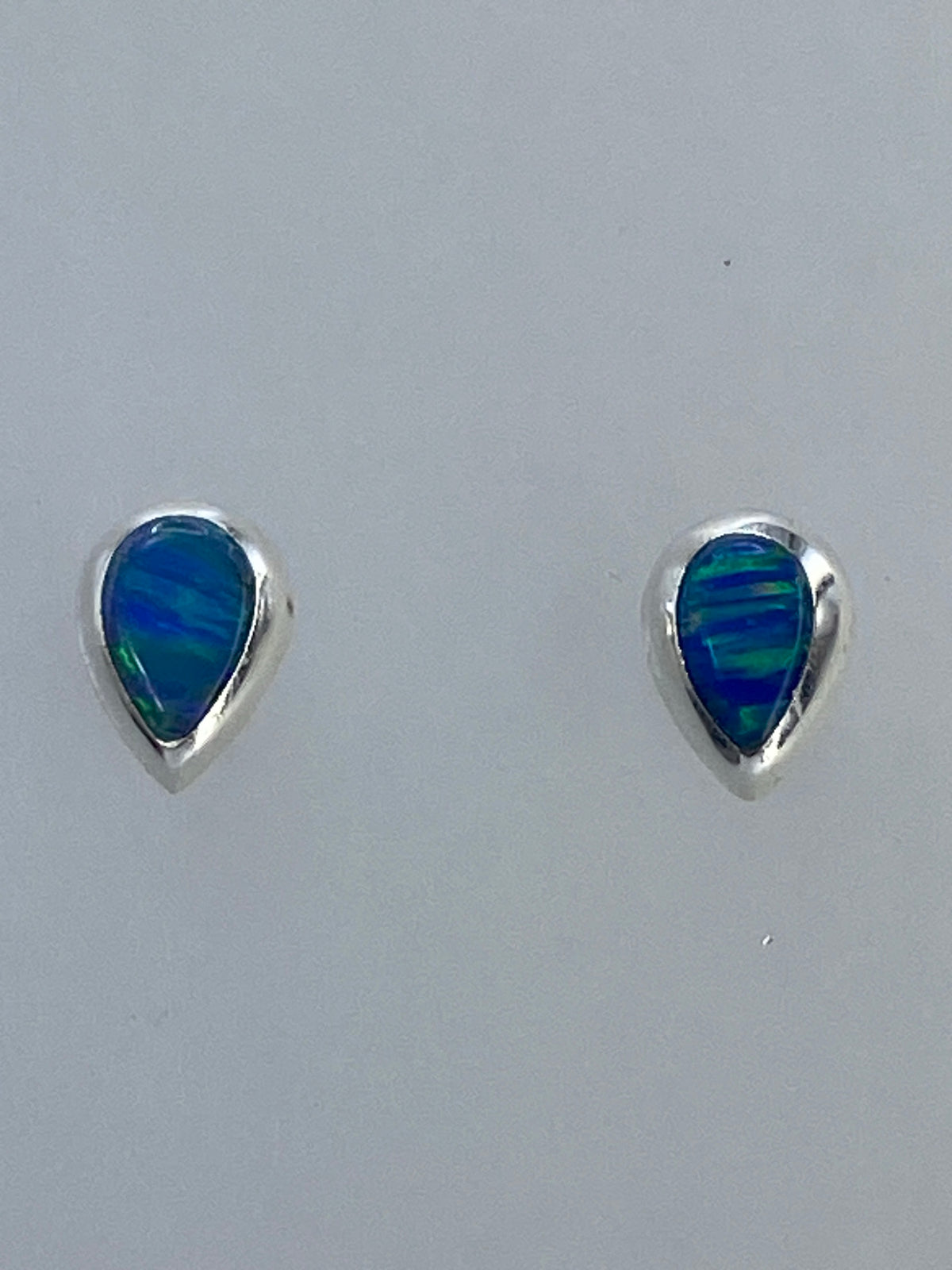 Aretes de plata con ópalo de fuego multicolor, vista frontal del par
