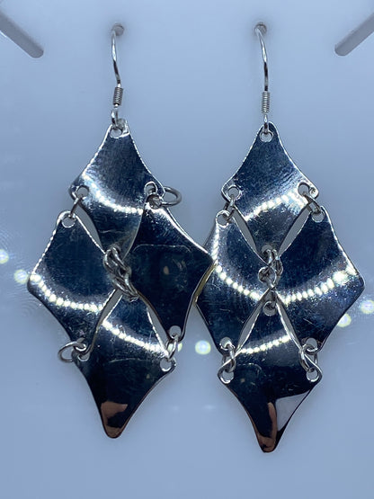Par de aretes geométricos escalonados de plata 925 sobre fondo azul
