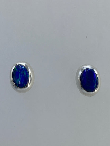 Aretes tipo botón con poste y mariposa en vista frontal
