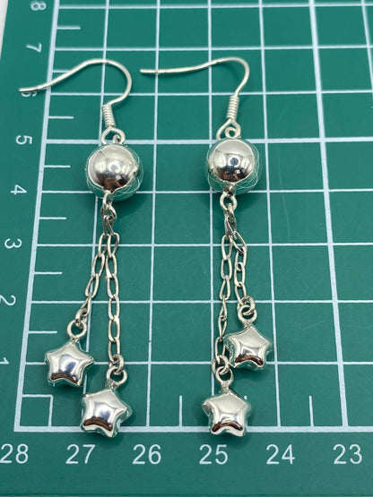 Aretes de plata pesados en escala de joyero mostrando 3.86 gramos del par