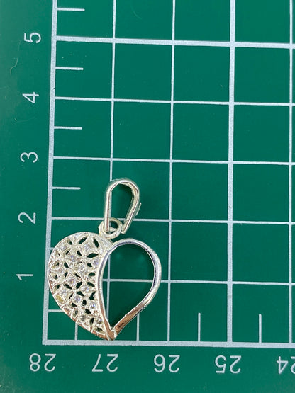 Dije corazón de plata 925 sobre fondo gris mostrando el Quinto
