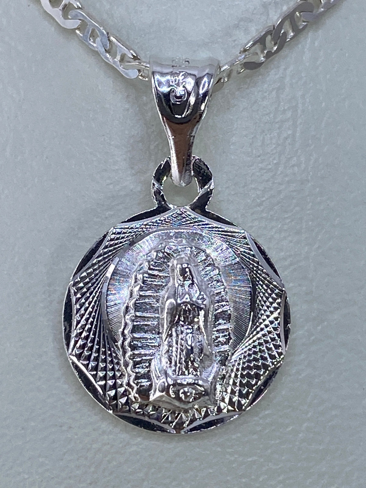 Dije de plata repujado con la Virgen de Guadalupe, tamaño 2.2 cm, vista frontal
