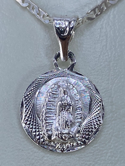 Detalle del repujado a mano: rostro y manto de la Virgen con rayos de luz