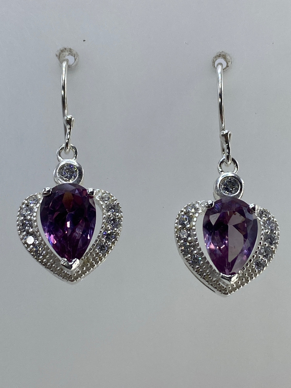 Par de aretes de plata en forma de corazón con circonia morada y micro-circonia cristalina, colgados en la oreja
