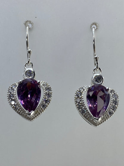 Par de aretes de plata en forma de corazón con circonia morada y micro-circonia cristalina, colgados en la oreja